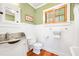 Bathroom with a white toilet, sink and beadboard walls at 406 S Gum St, Summerville, SC 29483