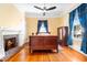 Bedroom featuring a fireplace with brick hearth, wood floors, and a wooden bed frame at 406 S Gum St, Summerville, SC 29483