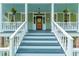 Welcoming front porch with classic columns and inviting seating, ideal for relaxing and enjoying the outdoors at 406 S Gum St, Summerville, SC 29483