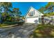 Detached garage with neutral paint, and a boat parked nearby against a background of lush trees under a clear blue sky at 406 S Gum St, Summerville, SC 29483