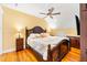 Comfortable bedroom boasts a ceiling fan, hardwood floors, and an elegant upholstered king bed at 406 S Gum St, Summerville, SC 29483