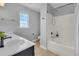 Bright bathroom featuring a shower-tub, vanity with solid countertops, toilet and window with natural light at 4060 Hartland St, Charleston, SC 29414