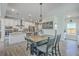 Open dining area featuring a rustic table with seating and a modern chandelier, adjacent to a stylish kitchen at 4314 Cotton Flat Rd, Summerville, SC 29485