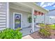 Inviting front porch adorned with patriotic decorations, potted plants, and comfortable seating, perfect for relaxing at 4314 Cotton Flat Rd, Summerville, SC 29485