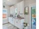 Bright kitchen with white cabinets, gray countertop and sink with bar area leading to a porch area at 4314 Cotton Flat Rd, Summerville, SC 29485