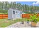 Backyard shed featuring white doors, gravel, and a well-maintained lawn at 4314 Cotton Flat Rd, Summerville, SC 29485