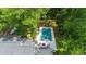 Aerial view of a modern pool and deck area surrounded by trees and adjacent to a stylish home at 441 Elfes Field Ln, Charleston, SC 29492