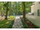 Stone path leads to a private backyard oasis with a pool, surrounded by lush trees and greenery at 441 Elfes Field Ln, Charleston, SC 29492