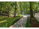 Backyard with stone path leading to a refreshing pool and lounge chairs amidst lush greenery at 441 Elfes Field Ln, Charleston, SC 29492
