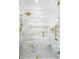 Luxurious bathroom with elegant marble tile, a frameless glass shower, and modern gold fixtures at 441 Elfes Field Ln, Charleston, SC 29492