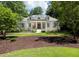 Charming white brick home featuring a landscaped front yard, columns, and a welcoming front porch at 441 Elfes Field Ln, Charleston, SC 29492