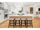 Bright, open kitchen with white cabinets, wooden island, and four bar stools for extra seating at 441 Elfes Field Ln, Charleston, SC 29492