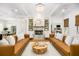 Elegant living room with fireplace, tan leather sofas, and hardwood floors at 441 Elfes Field Ln, Charleston, SC 29492
