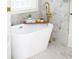 Close-up view of bright standalone tub, gold finishes, and marble tile backsplash at 441 Elfes Field Ln, Charleston, SC 29492