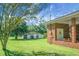 Large backyard featuring a brick porch, outbuilding, and ample green space at 4428 Maple Ridge Rd, Walterboro, SC 29488
