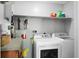 Functional laundry room featuring a washer, dryer, water heater, and storage shelves at 4428 Maple Ridge Rd, Walterboro, SC 29488
