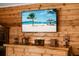 A rustic-themed living room featuring a wood accent wall with a tropical beach scene on a TV at 4428 Maple Ridge Rd, Walterboro, SC 29488
