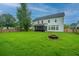 Expansive backyard with lush green grass, a fire pit, and a screened-in porch at 468 Maple Oak Ln, Charleston, SC 29414