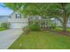 Charming two-story home with a well-manicured lawn and mature shade trees. Covered porch and attached garage at 468 Maple Oak Ln, Charleston, SC 29414