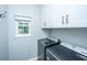 Functional laundry room with modern machines, storage cabinets, and a natural-light window at 468 Maple Oak Ln, Charleston, SC 29414