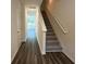 Inviting hallway with sleek wood floors, staircase with carpet runner and neutral walls at 495 Colchester Ct, Moncks Corner, SC 29461