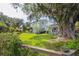 Beautiful backyard with expansive lawn, mature trees, and a charming guest house at 5017 W Liberty Park Cir, North Charleston, SC 29405