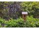 Cozy wooden birdhouse nestled in lush green foliage adds charm to the outdoor space at 5017 W Liberty Park Cir, North Charleston, SC 29405