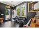 Stylish living room featuring dark walls, hardwood floors, large windows, and chic black chairs at 5017 W Liberty Park Cir, North Charleston, SC 29405