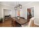 Elegant dining room with hardwood floors, stylish light fixture, and a view to an adjacent kitchen at 5110 Hyde Park Village Ln, North Charleston, SC 29405