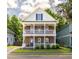 Charming two-story home features a brick facade and double balconies with lush landscaping at 5110 Hyde Park Village Ln, North Charleston, SC 29405