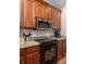 Close-up of a kitchen with stainless steel appliances, granite countertops, and wood cabinets at 5110 Hyde Park Village Ln, North Charleston, SC 29405