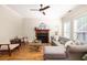 Well-lit living room with hardwood floors, a fireplace, a ceiling fan, and comfortable seating at 5110 Hyde Park Village Ln, North Charleston, SC 29405