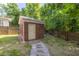 Rear brick storage shed surrounded by green foliage in the backyard with walkway at 5110 Hyde Park Village Ln, North Charleston, SC 29405