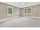 Bright bedroom featuring two large windows, light walls, and neutral carpet at 512 Whilden St, Mount Pleasant, SC 29464