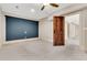 Bedroom with a ceiling fan, a dark accent wall, and an open wood door at 512 Whilden St, Mount Pleasant, SC 29464