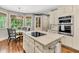 Bright kitchen featuring an island with cooktop, stainless-steel appliances, breakfast nook, and large windows at 512 Whilden St, Mount Pleasant, SC 29464