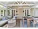 Covered outdoor space with comfortable seating, dining area, and access to the interior through elegant French doors at 512 Whilden St, Mount Pleasant, SC 29464