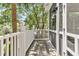 A cozy screened-in porch with wood flooring, white railing, and a screen door offers a peaceful outdoor retreat at 512 Whilden St, Mount Pleasant, SC 29464