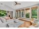 Cozy sun room featuring large windows, hardwood floors, comfortable seating, and a view of lush greenery at 512 Whilden St, Mount Pleasant, SC 29464