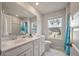 Bright bathroom with double sinks, a large mirror, and a window with a pleasant outdoor view at 513 Richfield Way, Summerville, SC 29486