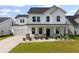 Charming two-story home featuring a white exterior, black roof, covered front porch, and well-manicured lawn at 513 Richfield Way, Summerville, SC 29486