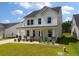 Beautiful two-story home boasting a covered front porch with stone accents, manicured lawn, and white siding at 513 Richfield Way, Summerville, SC 29486