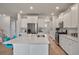 Bright kitchen features white cabinets, stainless steel appliances, large island with quartz countertops and wooden floors at 513 Richfield Way, Summerville, SC 29486