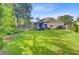 Expansive backyard featuring lush green grass, mature trees, and well-kept garden beds at 5406 E Crosland Ct, North Charleston, SC 29420