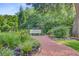 Charming backyard garden with a brick pathway and a peaceful bench setting at 5406 E Crosland Ct, North Charleston, SC 29420