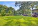 Lush green backyard with mature trees, a garden, and well-maintained lawn space at 5406 E Crosland Ct, North Charleston, SC 29420