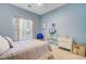 Comfortable bedroom with blue walls, a ceiling fan, neutral carpet, and a window with natural light at 5406 E Crosland Ct, North Charleston, SC 29420