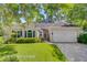 Charming single-story home with manicured lawn, beautiful landscaping, and a two-car garage at 5406 E Crosland Ct, North Charleston, SC 29420