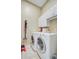 Efficient laundry room with front-load washer and dryer, storage cabinets, and accessories at 5406 E Crosland Ct, North Charleston, SC 29420