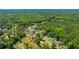 Wide aerial shot exhibits a community by a expansive wooded area with houses of varying styles and colors at 565 Estates Dr, Walterboro, SC 29488